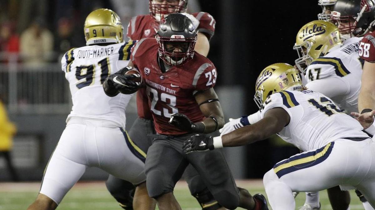 Washington State running back Gerard Wicks (23) runs with the ball in front of UCLA linebacker Jayon Brown (12) during the second half of an NCAA college football game against UCLA in Pullman. Washington State's four-game win streak and return to contention in the Pac-12 can be attributed to the Cougars determination to run the ball on offense.