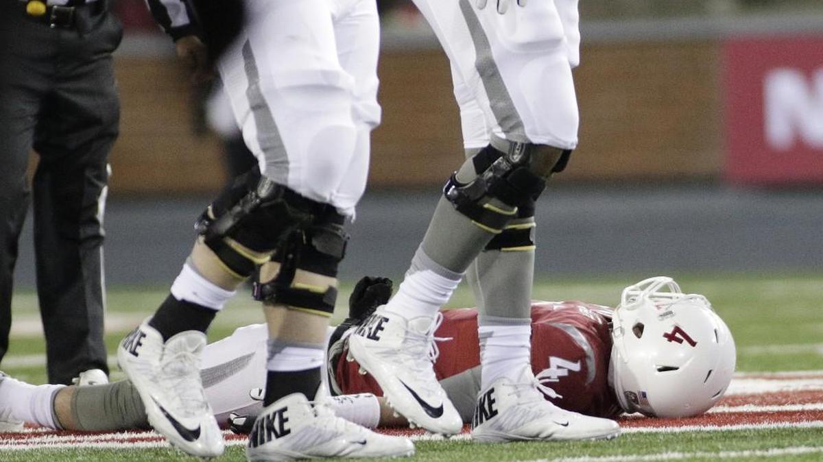 Washington State quarterback Luke Falk, who was later carted off the field, rests after being tackled during the second half Saturday night against Colorado, in Pullman. Cougars coach Mike Leach refused to discuss Falk’s status for the Apple Cup game against Washington on Friday in Seattle.
