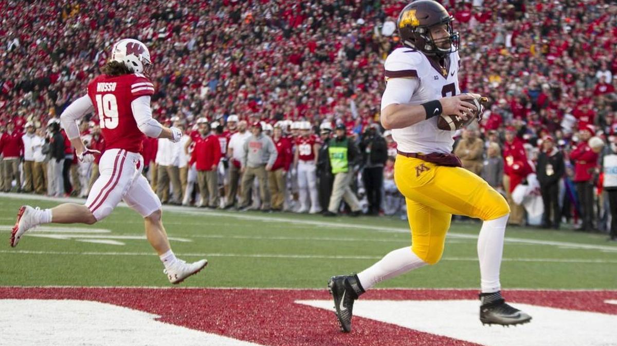 Minnesota quarterback Mitch Leidner scores a touchdown against Wisconsin safety Leo Musso during the first half of an NCAA college football game Saturday, Nov. 26, 2016, in Madison, Wis.