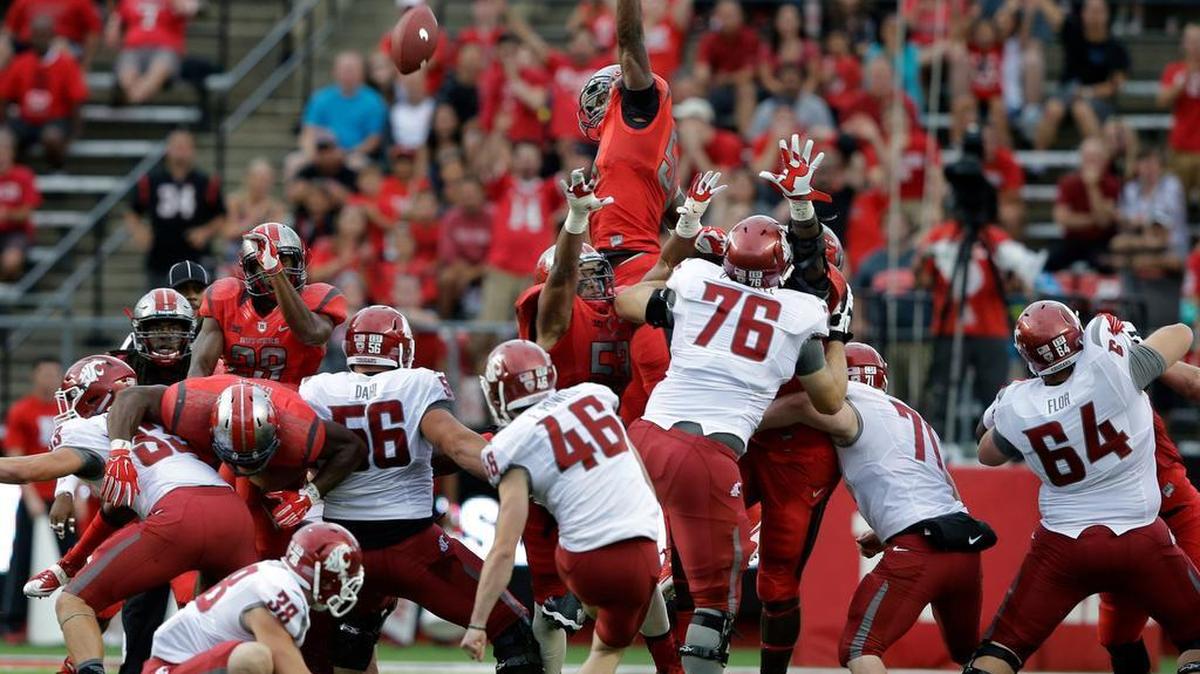 
Rutgers defensive lineman Kemoko Turay leaps high to try to block a field goal by WSU kicker Erik Powell (46) during the first half. Powell was 3 for 3 in kicking field goals of 37, 46 and 47 yards. 
