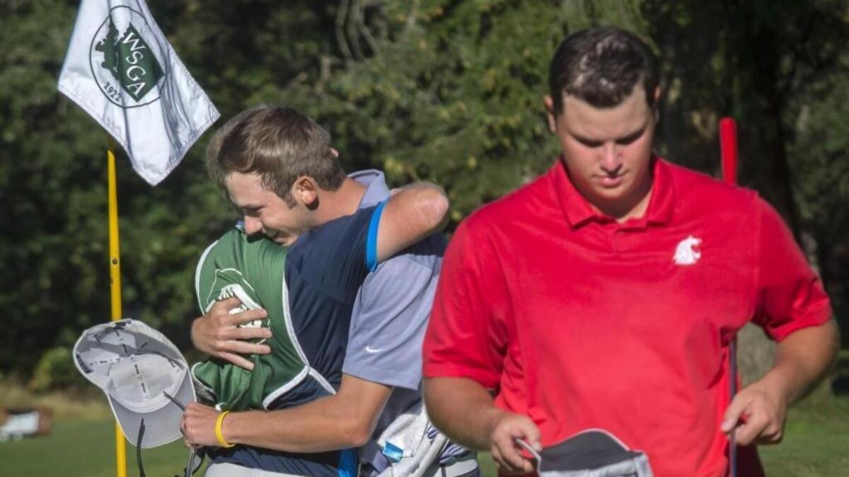 Chase Carlson hugs caddie John Dimmer after winning the Washington State Men’s Amateur at Tacoma Country and Golf Club on Thursday. Derek Bayley, right, walks away after losing on the sixth hole of a playoff.