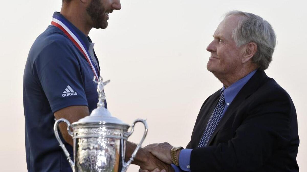 Dustin Johnson shakes hands with Jack Nicklaus after winning the U.S. Open at Oakmont Country Club on Sunday. It was Johnson’s first victory in a major after several near-misses.