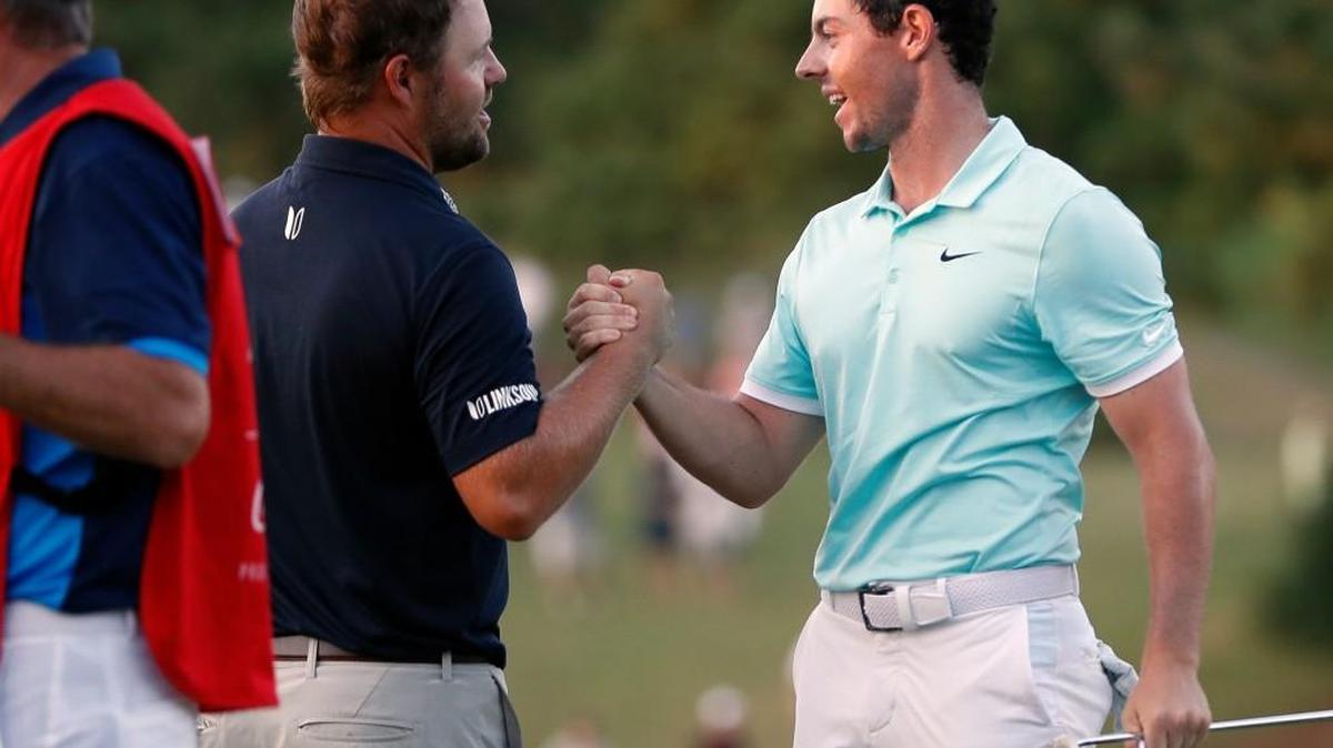Rory McIlroy, right, shakes hands with Ryan Moore on Sunday after winning at the Tour Championship in a playoff at East Lake Golf Club in Atlanta. Moore, a Puyallup native, was selected for the U.S. Ryder Cup team shortly after the tournament ended.