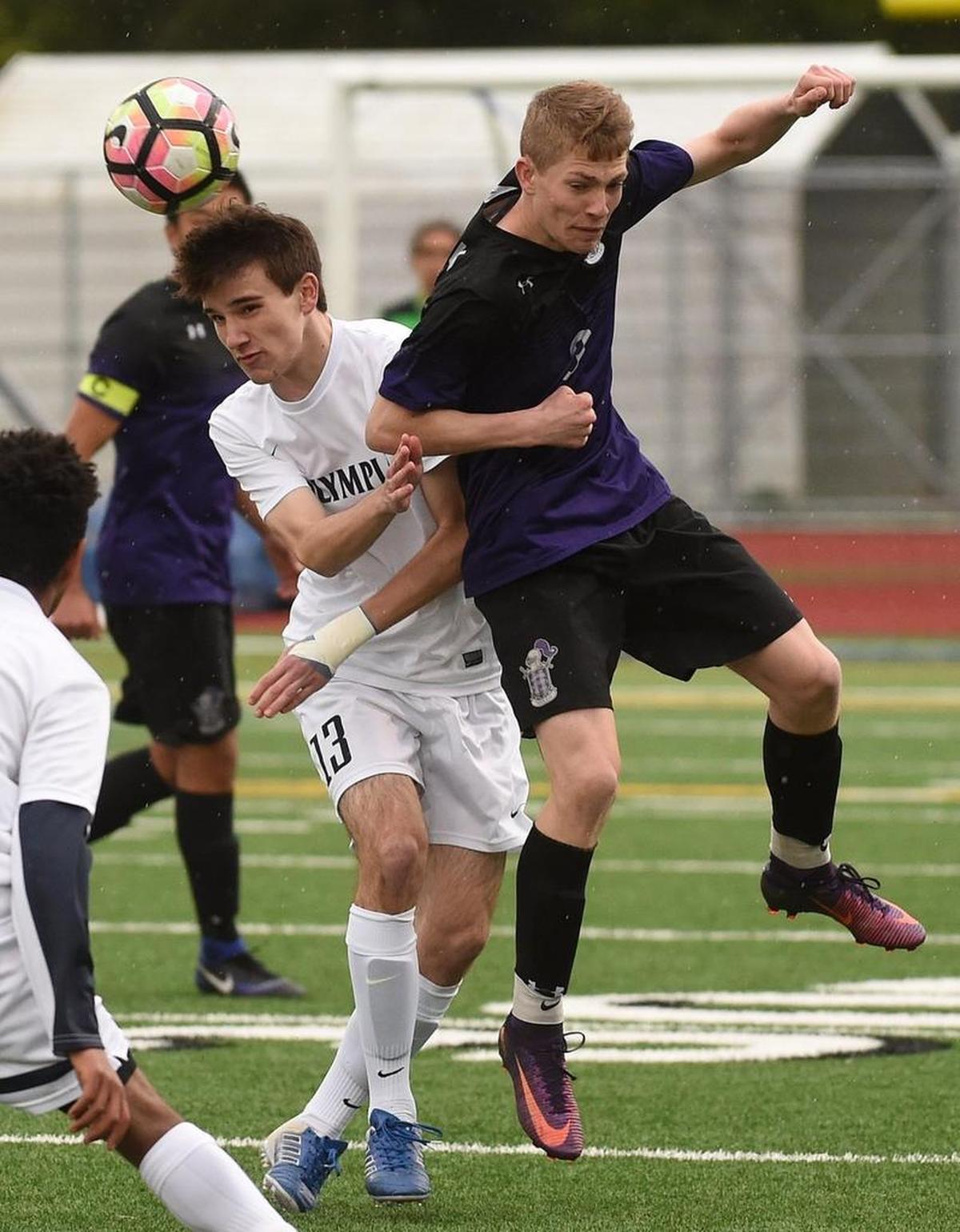 Olympia forward Adam Rapacz (13) collides with Kamiak defender Cade Cooke Tuesday as the Bears hosted visiting Knights in the first round of the 4A state tournament.