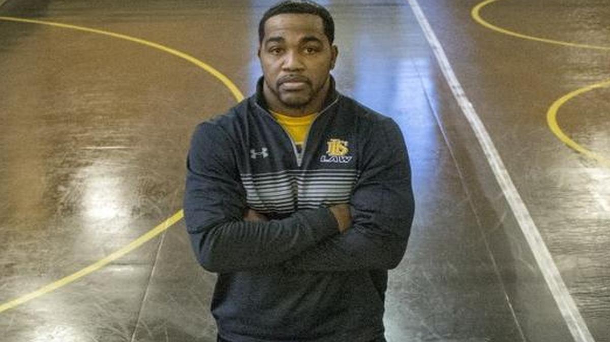Lincoln High School wrestling coach Greg Ford is shown in December with Will Willsey (left, 220 lbs.), JJ Dixon (right, 182) and Jeramias Sandavol (132).