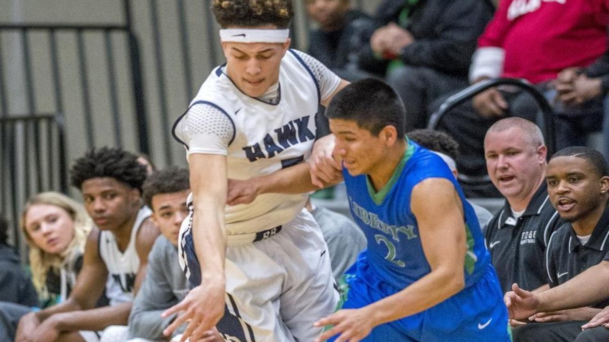 Tre'Vonne Dorfner of River Ridge High School battles with David Rodriguez of Liberty in front of the River Ridge bench in a AA boys basketball playoff game at Foss High School in Tacoma, February 17, 2016.