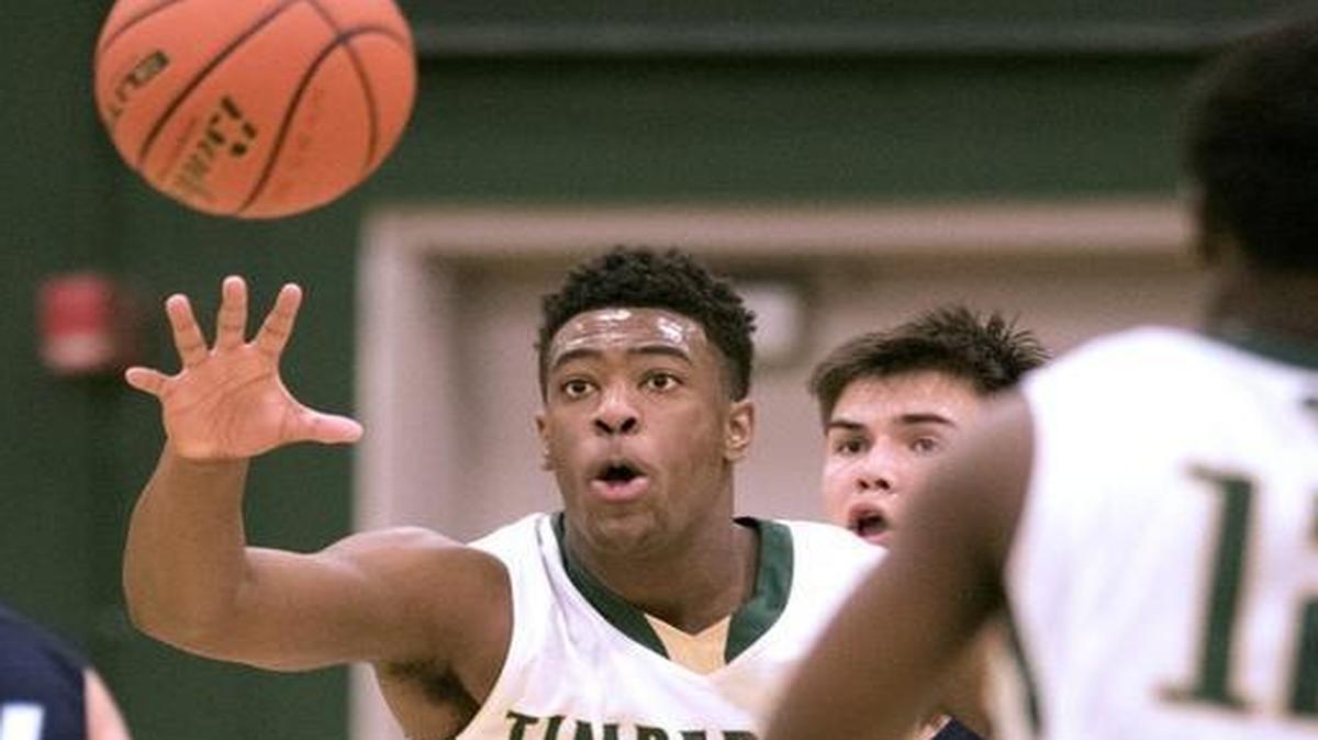 Timberline’s Jarryn Bush reaches for a pass as Olympia High’s Hunter Sipe, middle, defends. Bush has averaged 21 points in six playoff games, helping lead the Blazers to the Class 4A state tournament.