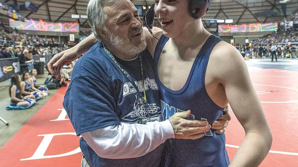Olympia's Layn Pannkuk hugs his coach Greg Hargrave after beating Ryden Fu of Tahoma in their 4A 138 lb. match during the first day of the Mat Classic XXVIII at Tacoma Dome.