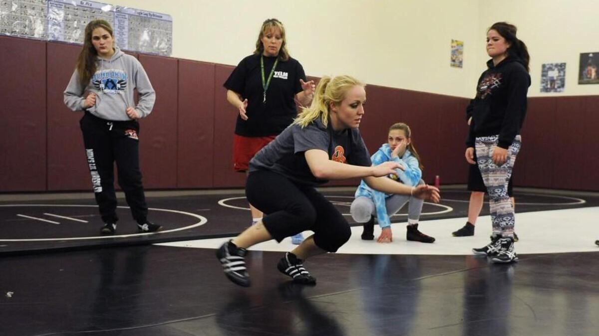 Rainier coach Cassie Scogin demonstrates a slide move during a wrestling practice at Yelm. Amy Earley, center, is Scogin’s aunt.