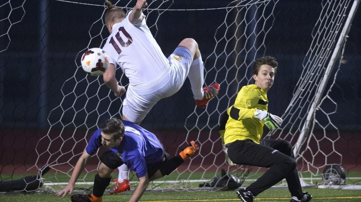 Capital’s Sam Reimertz (10) takes a tumble over North Thurston defender Kody Marcott after Rams goalkeeper Diego Roderiguez (right) knocks the ball away Thursday night at Ingersoll Stadium in Olympia .