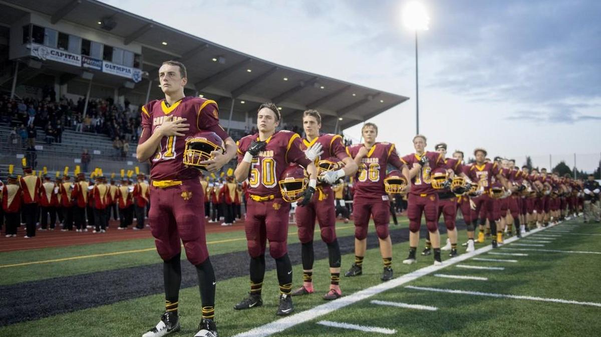 Capital junior quarterback Grant Erickson (left) and the Cougars before a Friday night football game at Ingersoll Stadium in Olympia on Sept. 29, 2017.