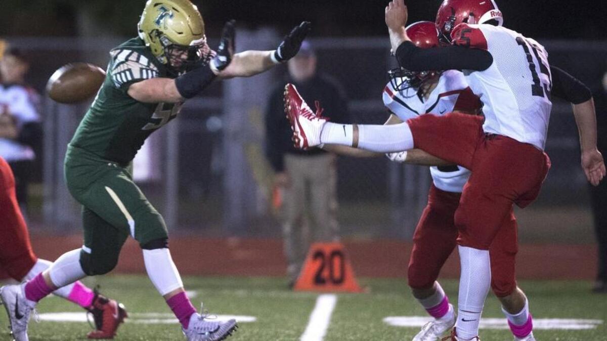 Timberline’s Conner Warrick puts the pressure on Yelm quarterback Kyle Robinson as he quick kicks during a football game at South Sound Stadium in Lacey on Oct. 6, 2017.