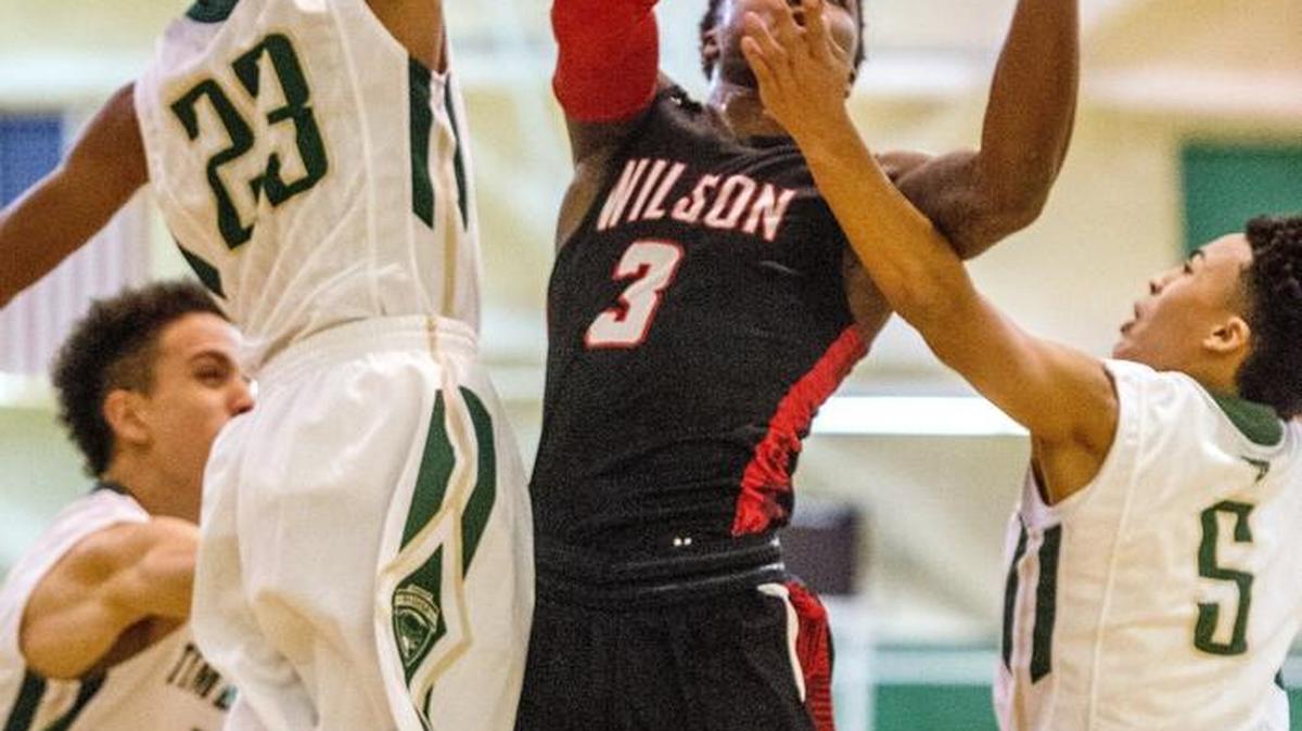 Wilson guard David Jenkins Jr. (3) attempts a shot against the defense of Timberline’s Mika Allison,left, Jake Williams (23) and Casson Rouse (5) on Saturday at Highline College in Des Moines.