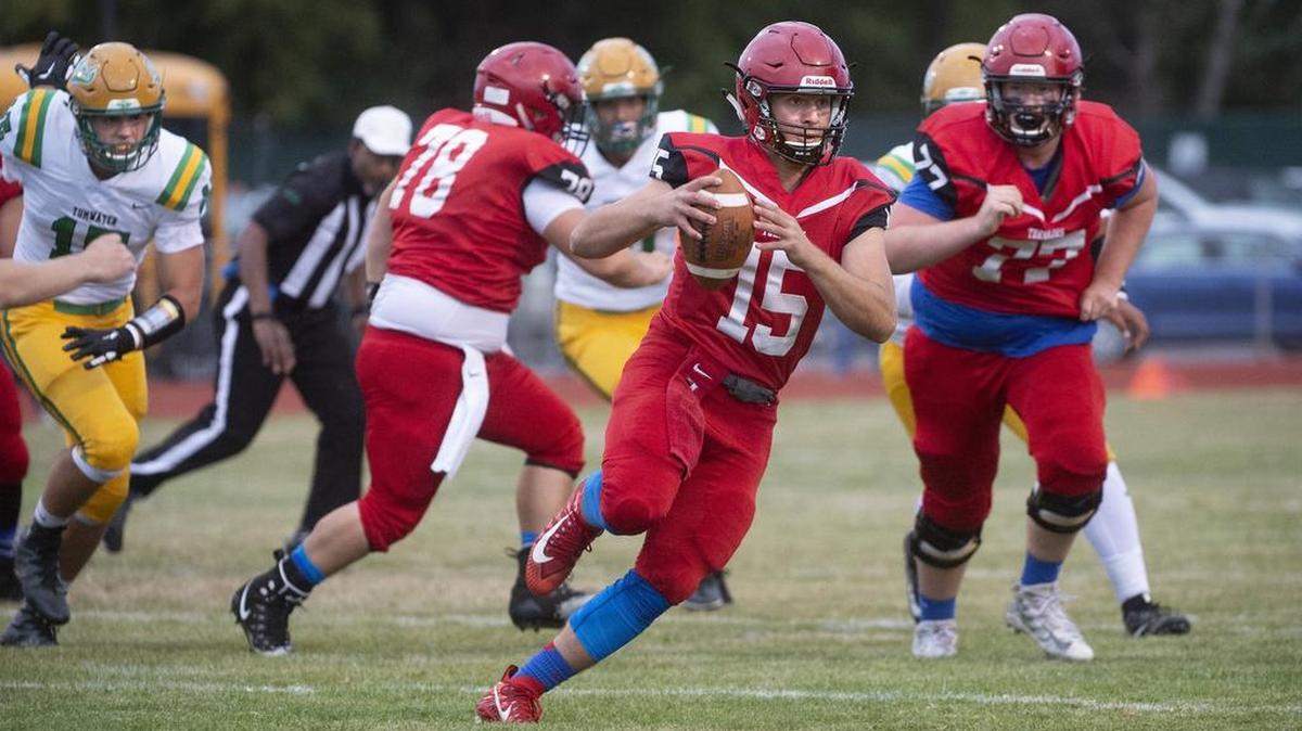 Yelm quarterback Kyle Robinson scrambles away from the Tumwater defense during Friday night’s football game at Yelm High School on Sept. 7, 2018.