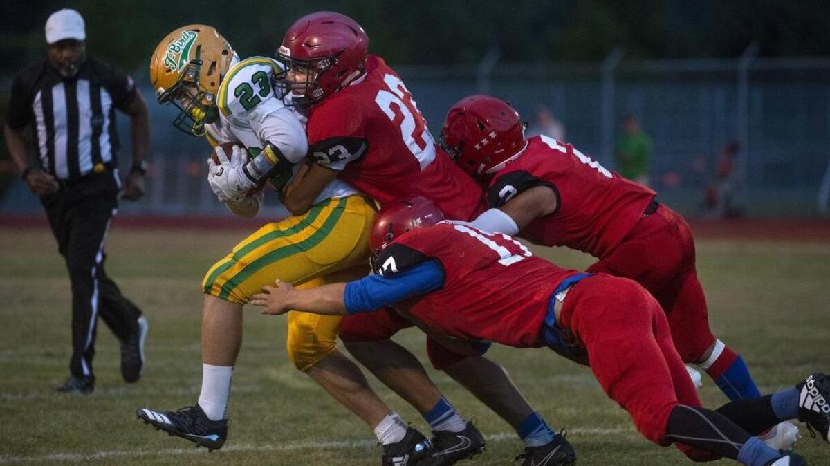 Tumwater running back Zane Murphy is gang tackled for a loss by Yelm defenders Derrick Platt (23), Jason Nelson (17) and Steven Reyes during Friday night’s football game at Yelm High School on Sept. 7, 2018.