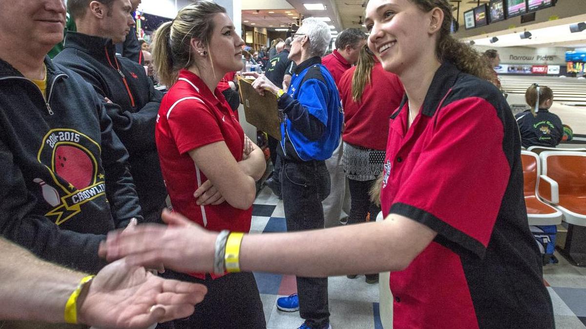 Madi Hawkins of Capital High School is congratulated Friday after her second game during the opening day of the state girls championships at Narrows Plaza Bowl in University Place.