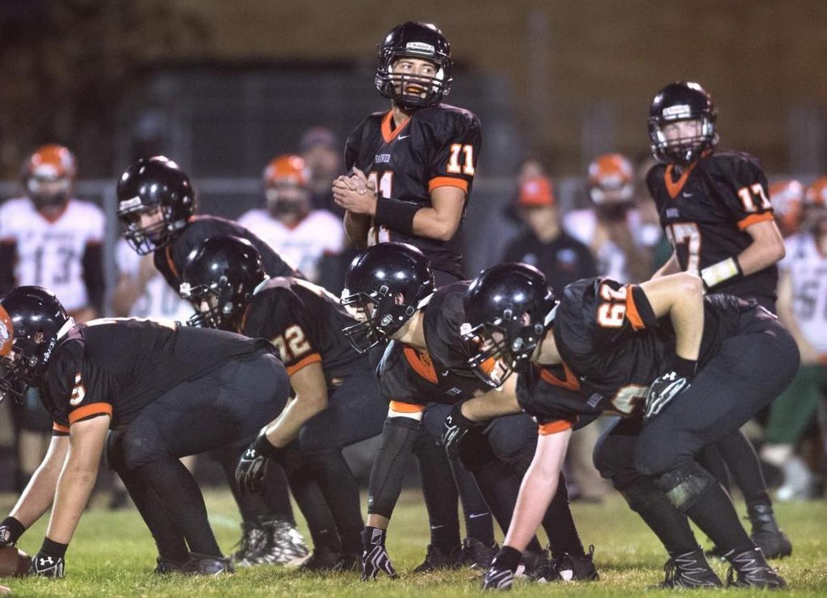 Rainier quarterback Zach Lofgren (11) and the Mountaineers offense wait for a play call during a football game against Morton-White Pass at Rainier High School on Sept. 21, 2017.