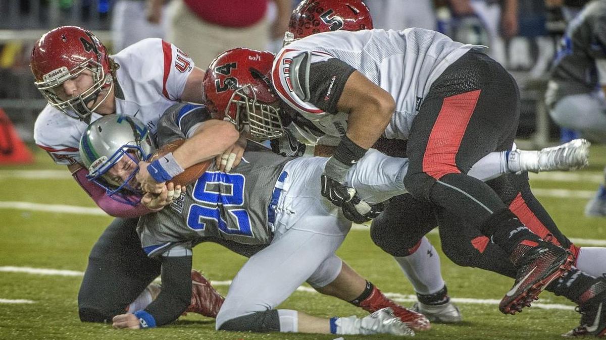 Archbishop Murphy’s Dirk Wilson, left, and Jackson Yost bring down Liberty quarterback Austin Regis at the Tacoma Dome.