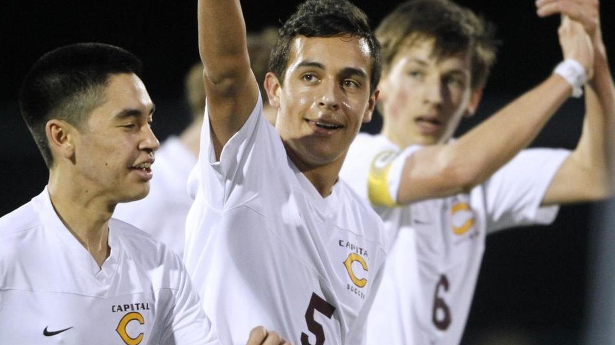 Capital’s Nigel El-Sokkary (5) is flanked by teammates Alan Ryan (16) and Oni Mayer as he salutes the fans after scoring a goal against Tumwater on Feb. 17, 2015. El-Sokkary, who is a senior this year, was the Cougars leading scorer last season with 17 goals and 20 assists.