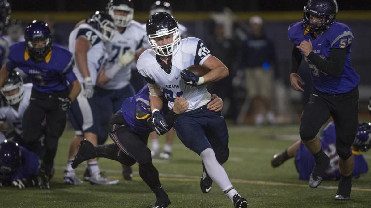 Olympia running back Scott Gunther tries to fight off Issaquah defensive back Bryce Hughes during Friday night's 4A football district playoff game at Gary Moore Stadium in Issaquah on Nov. 6, 2015.