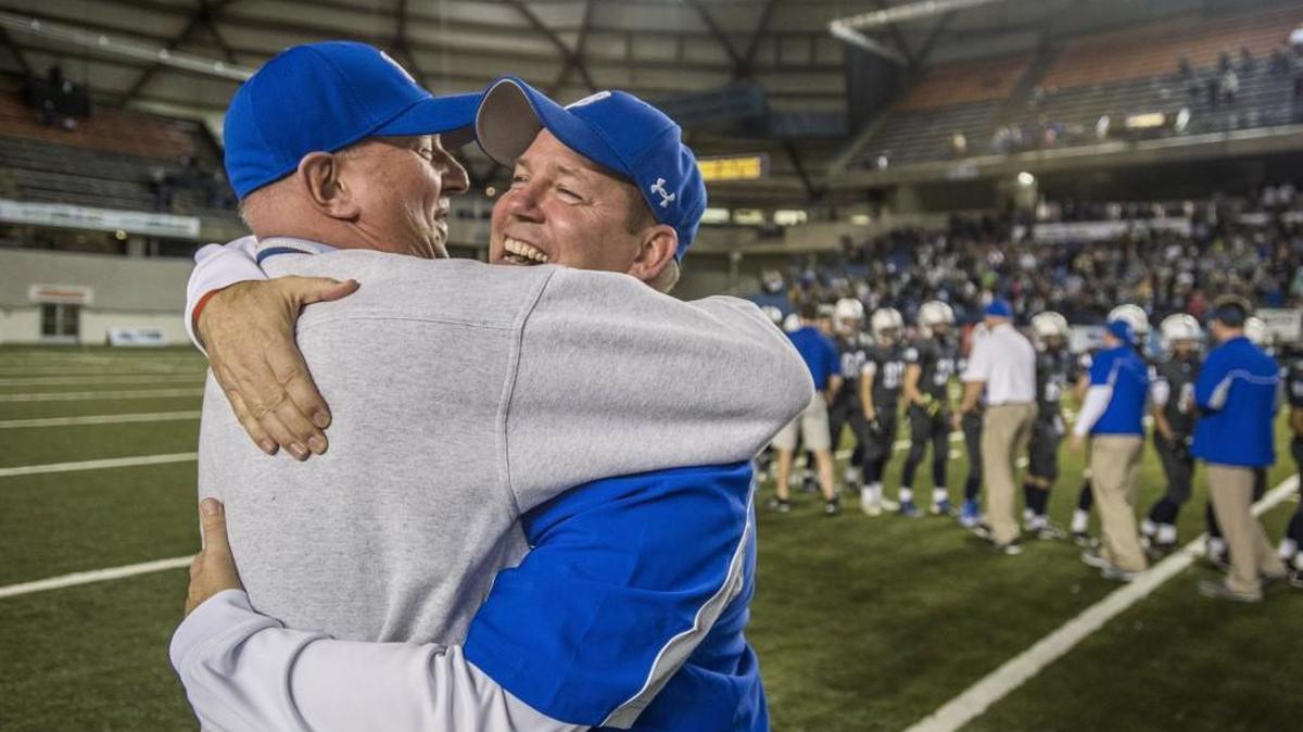 Bothell High principal Bob Stewart (left) hugs head coach Tom Bainter after Bothell won the Class 4A football championship Dec. 6 in the Tacoma Dome. The WIAA agreed to a new three-year contract on Monday to keep the championships in the Tacoma Dome.