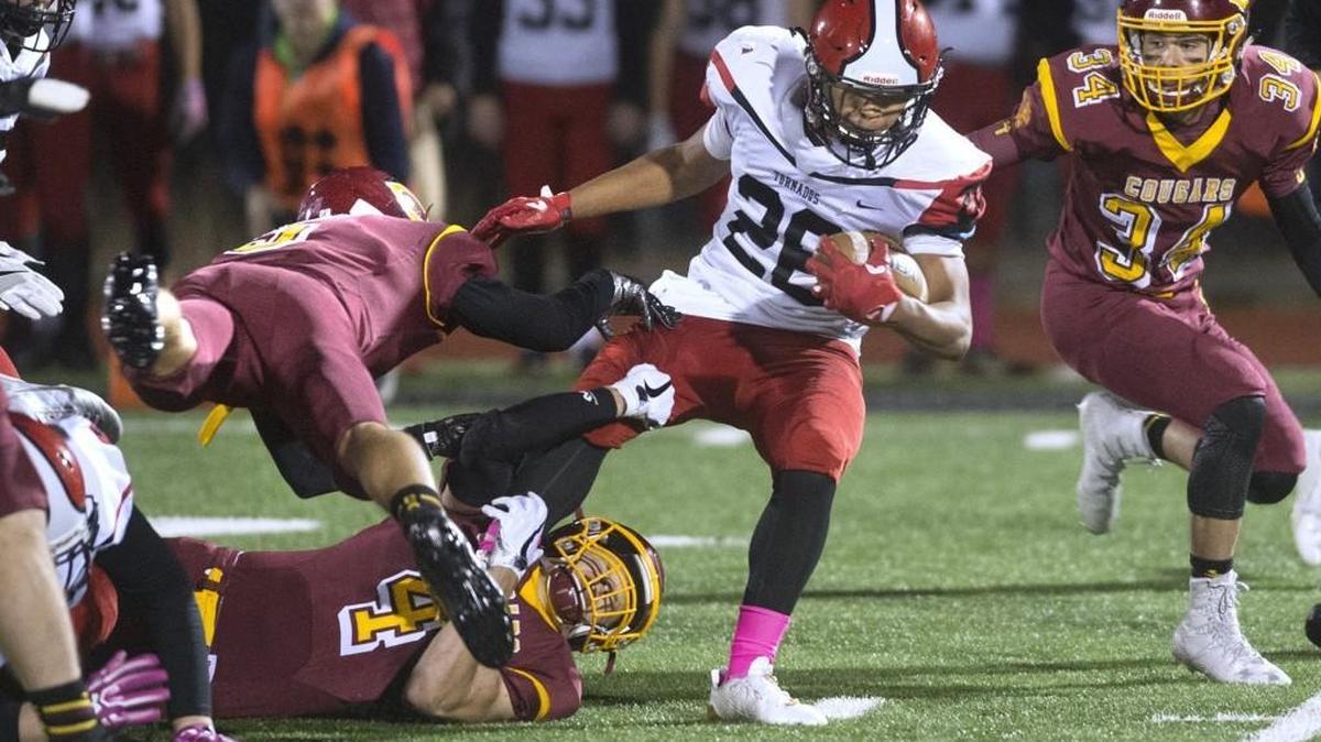 Capital defenders Jack Collard (4), Ryan Guscott (5) and Chad Garland (34) fight to bring down Yelm running back James Palmer during Friday night's football game at Ingersoll Stadium in Olympia on Oct. 13, 2017.