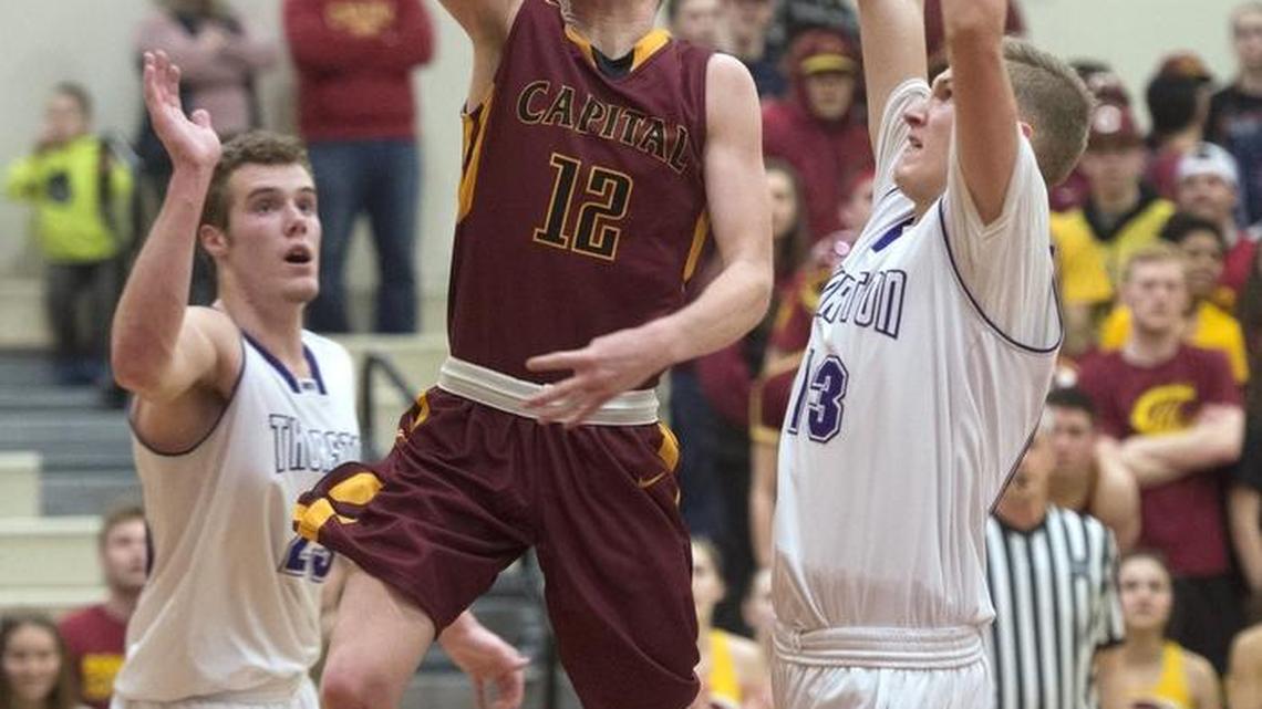 Capital's Matt Mickelson puts up a shot between North Thurston defenders Clay Christian (left) and Aaron Stone during Saturday afternoon's 3A boys basketball district playoff game at Capital High School in Olympia on Feb. 18, 2017.