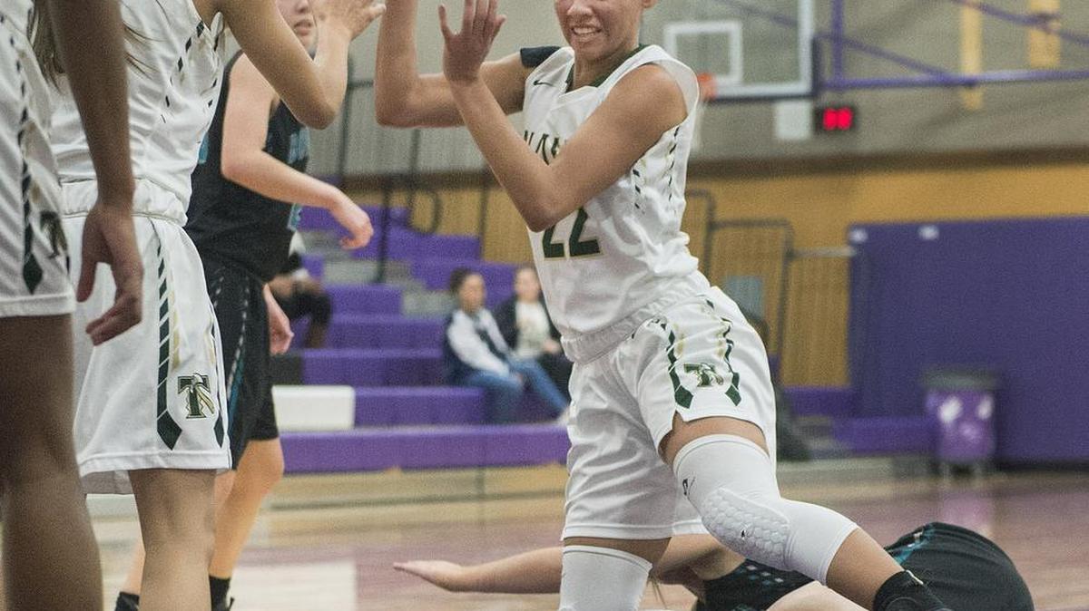 Timberline’s Kiara Brooks passes off to a teammate in the first half Thursday night — even with her feet tangled up with a Bonney Lake player. Brooks finished with 16 points in the Timberline victory in Lacey.