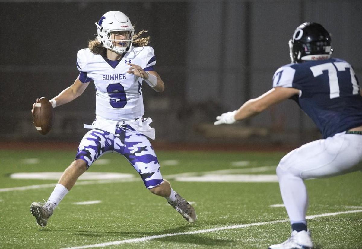 Sumner quarterback Luke Ross is pressured by Olympia defender Logan Wood during a football game at Ingersoll Stadium in Olympia on Oct. 6, 2017.