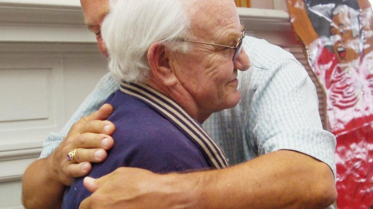 Former Olympia High football coach Robert “Bob” Dunn, left, gets a hug from Capital High football coach Wayne Sortun during Sortun’s retirement party.