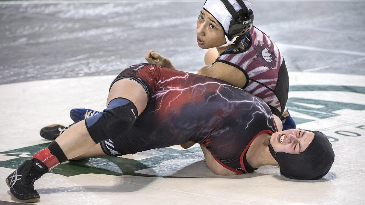 Yelm’s Bree Hyder grimaces as last year’s state champion, Grandview’s Viannei Perez, applies pressure before pinning Hyder in their 105-pound match Friday. Hyder won her next match to remain alive in the tournament.