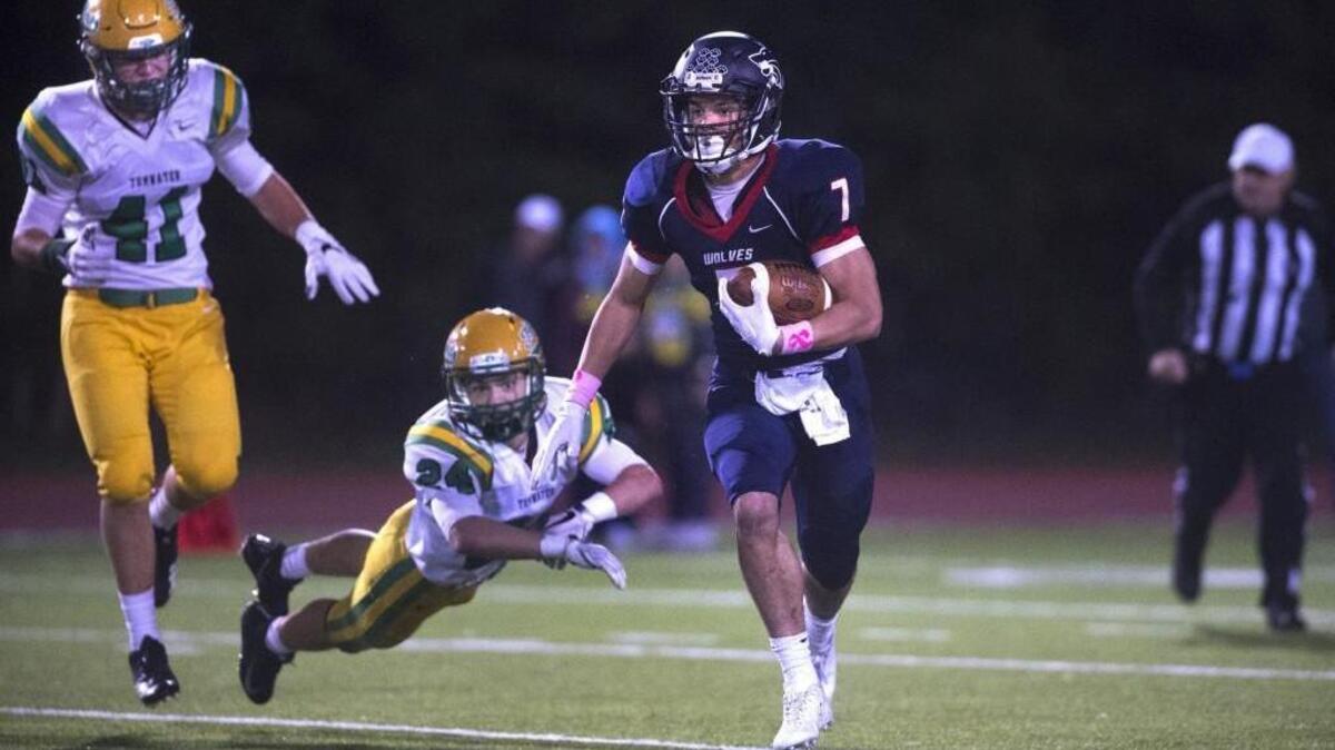 Black Hills running back Jaden Toussaint breaks away from Tumwater defenders Jack Neibauer (41) and Mason Burbidge during Friday night’s Pioneer Bowl crosstown rivalry game at Tumwater District Stadium on Oct. 20, 2017.