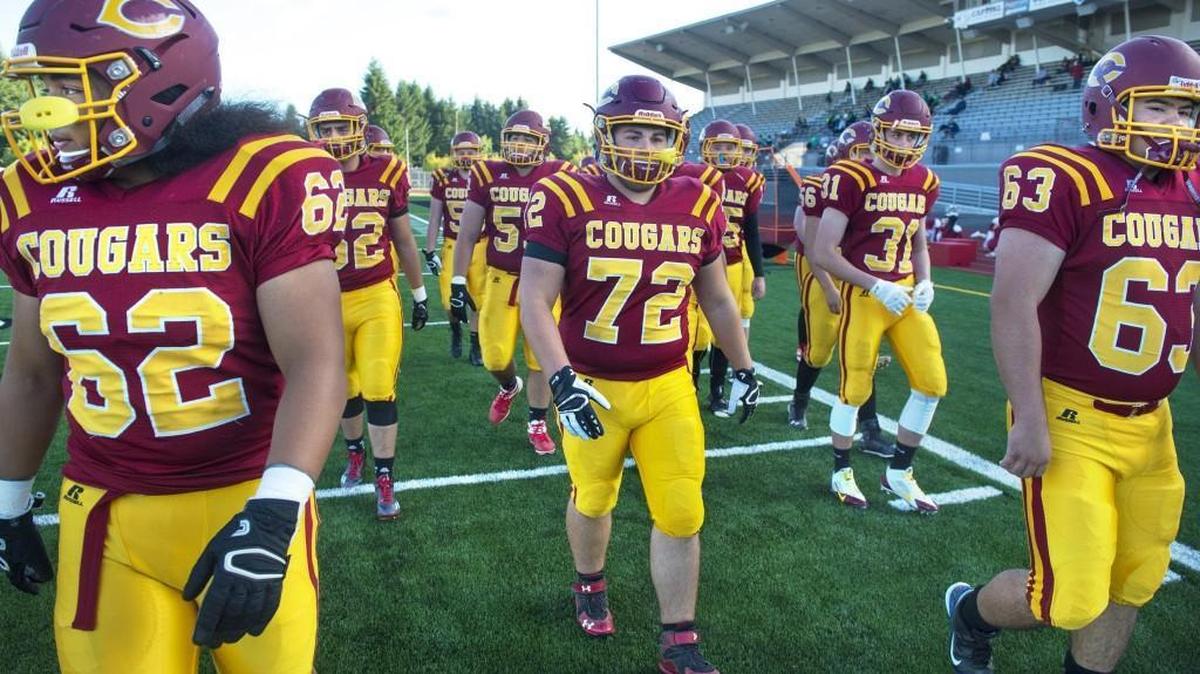 
Capital's David Ainuu (62), Brad Clark (62), Nathan Tyler (31) and Spencer Settle (63) walk with teammates onto the field at Ingersoll Stadium in Olympia before Friday night's season-opening football game against Tumwater on Sept. 4, 2015.
