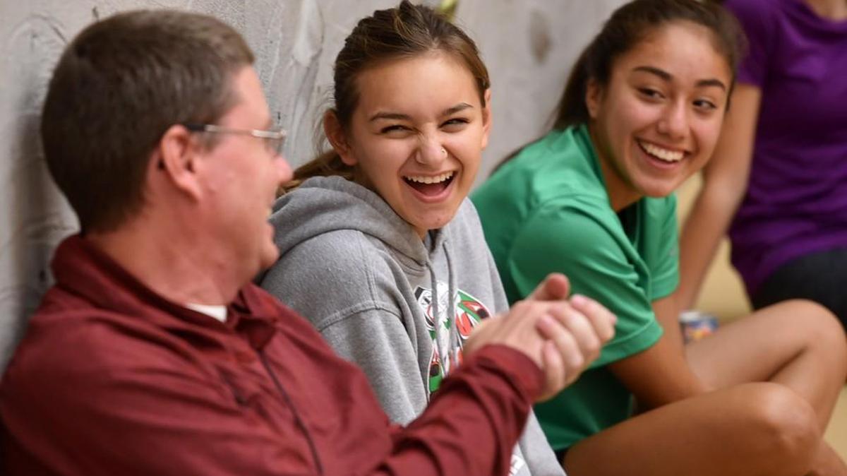 
Capital cross country teammates Inanna McCarty, center, and Naomi Reyes, right, have some fun with their coach Kevin Wright before a practice at Capital High. 
