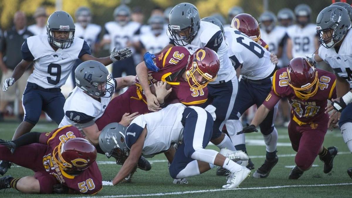Capital senior running back Nate Tyler (31) powers into River Ridge defenders Hunter Prida (14), Tomasi Manu (1) and Lamar Cambell (12) during Friday night’s football game at Ingersoll Stadium in Olympia on Sept. 1, 2017.