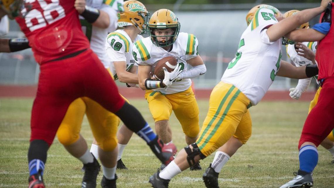 Tumwater running back Dylan Loftis looks for a hole in the Yelm defense during Friday night’s football game at Yelm High School on Sept. 7, 2018.