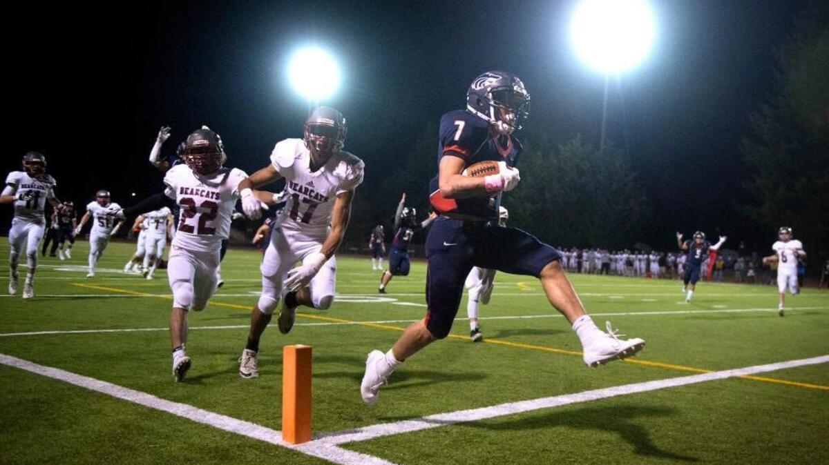 Black Hills running back Jaden Toussaint pops into the end zone for a 25-yard overtime touchdown run in front of W.F. West defenders Jett Bowers (22) and Jordan Thomas on Oct. 13 at Tumwater District Stadium.