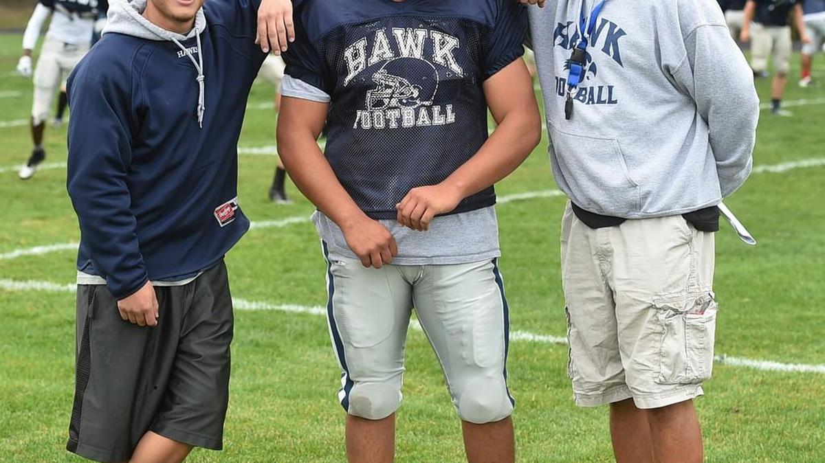 Flanked by his father and River Ridge assistant coach Bruce Carter, right, and cousin Jeremy Camacho, a River Ridge alum and former standout football player, junior linebacker Zach Carter is tackling family tradition as he nears cousin Elijah Camacho's school record for tackles.