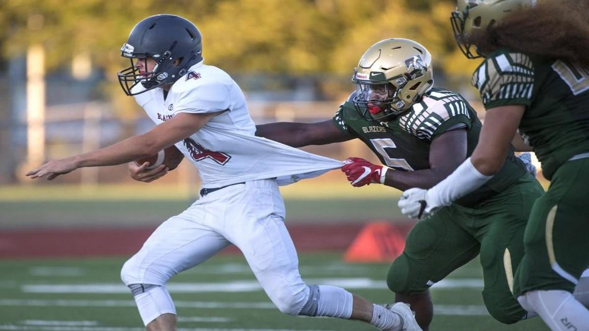 Timberline linebacker Ty Edmond (right) tries to wrangle Black Hills quarterback Ethan Loveless during last week’s season opener at South Sound Stadium in Lacey. The Blazers are ranked eighth in Class 3A for Week 2 after the 35-7 win over the Wolves.