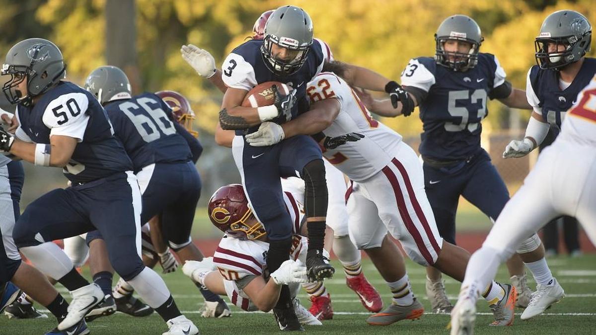 River Ridge running back Trey Dorfner tries to fight off Capital defenders Nate Smith and David Ainuu (62) during a game earlier this season at South Sound Stadium in Lacey.