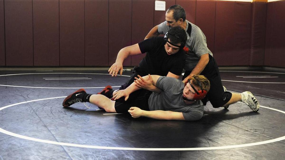 Yelm coach Gaylord Strand works with Jeremy Smith (in black) and Tyler Losch at practice. “He fit in right away,” Strand says of Smith, who transferred from Bethel.