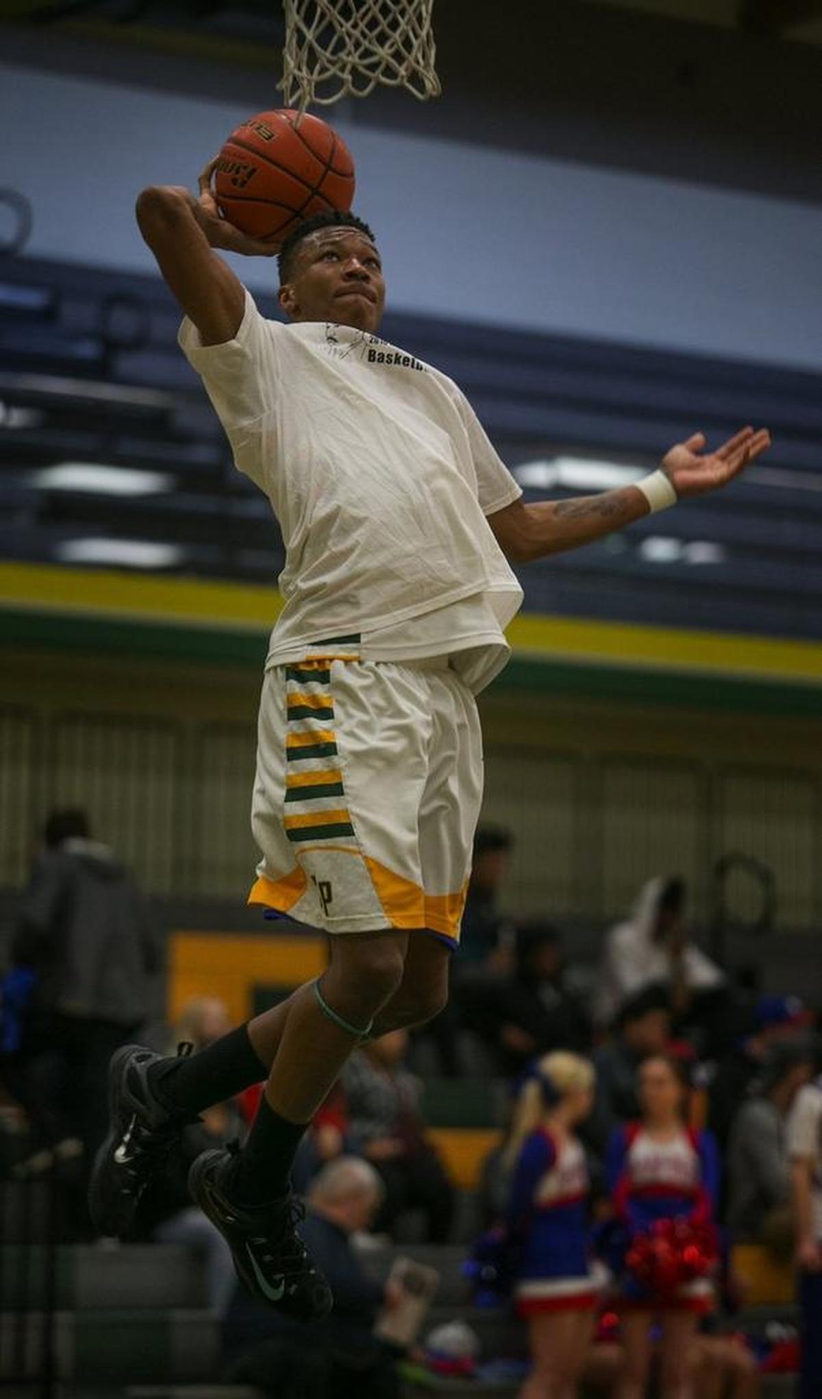 Clover Park High School basketball player Semaj Booker goes up for a basket before playing in the Clover Park Warrior’s playoff game against the Washington Patriots at Foss High School in Tacoma, WA, Monday, February 15, 2016.