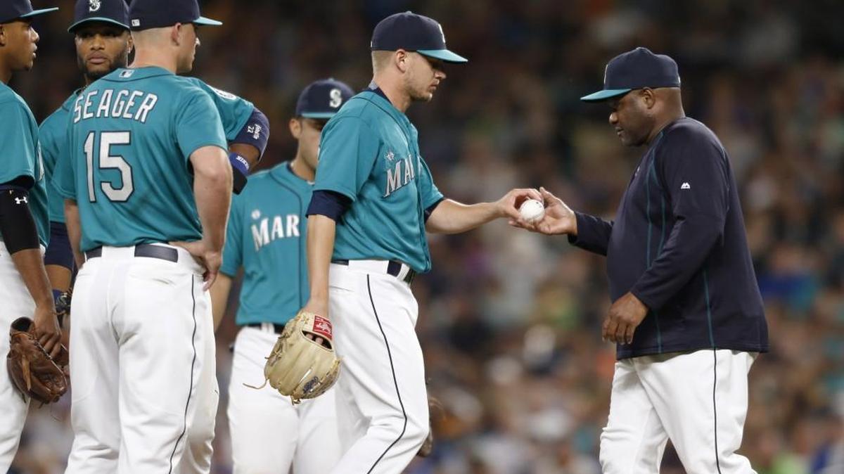 
Seattle Mariners manager Lloyd McClendon, right, takes the ball from relief pitcher Rob Rasmussen in the eighth inning of an 11-4 loss to the Chicago White Sox on Friday. The Mariners’ bullpen has the American League’s worst ERA since the All-Star break. 
