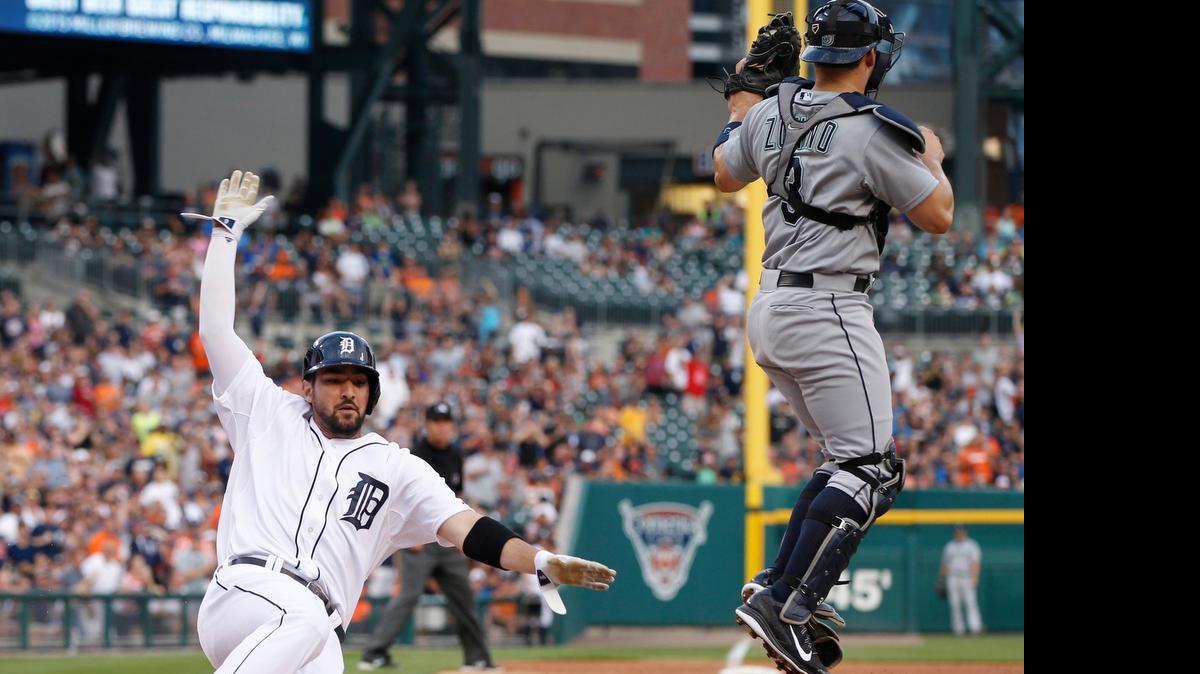 
Nick Castellanos of the Tigers slides in for the second run on the double by James McCann in back of Mariners catcher Mike Zunino during the second inning Monday at Detroit’s Comerica Park.
