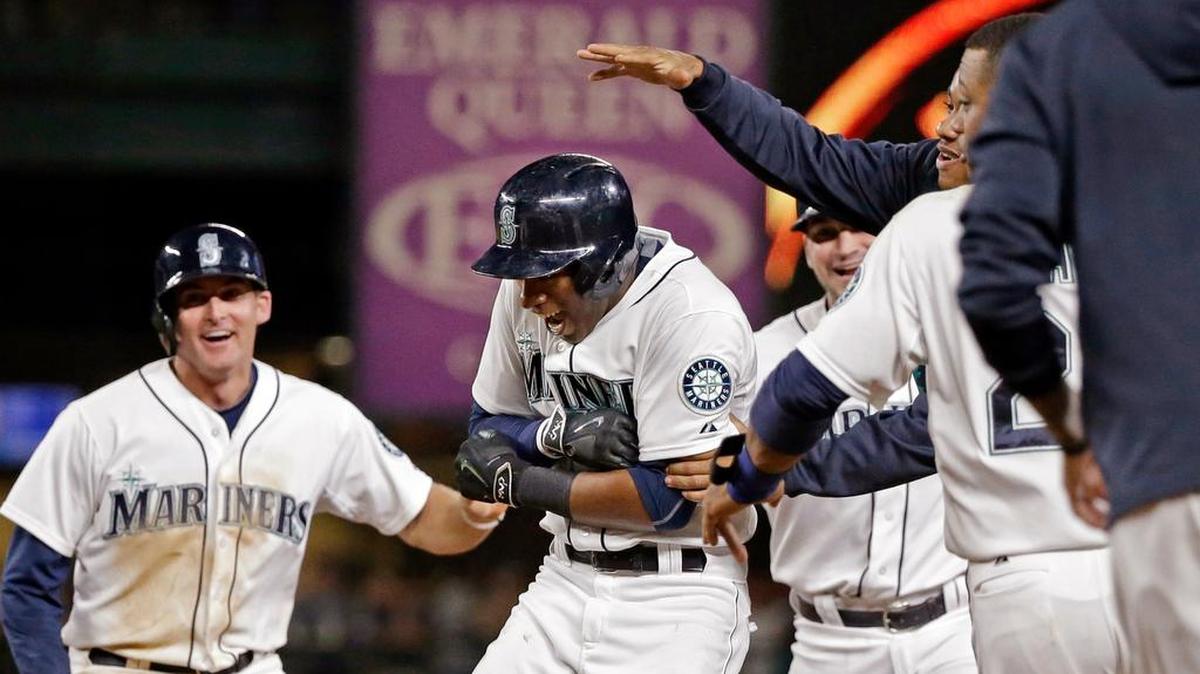 
Seattle Mariners' Austin Jackson, center, is mobbed by teammates after hitting in the game-winning run against the Baltimore Orioles in the 10th inning of a baseball game Tuesday, Aug. 11, 2015, in Seattle. The Mariners won 6-5.
