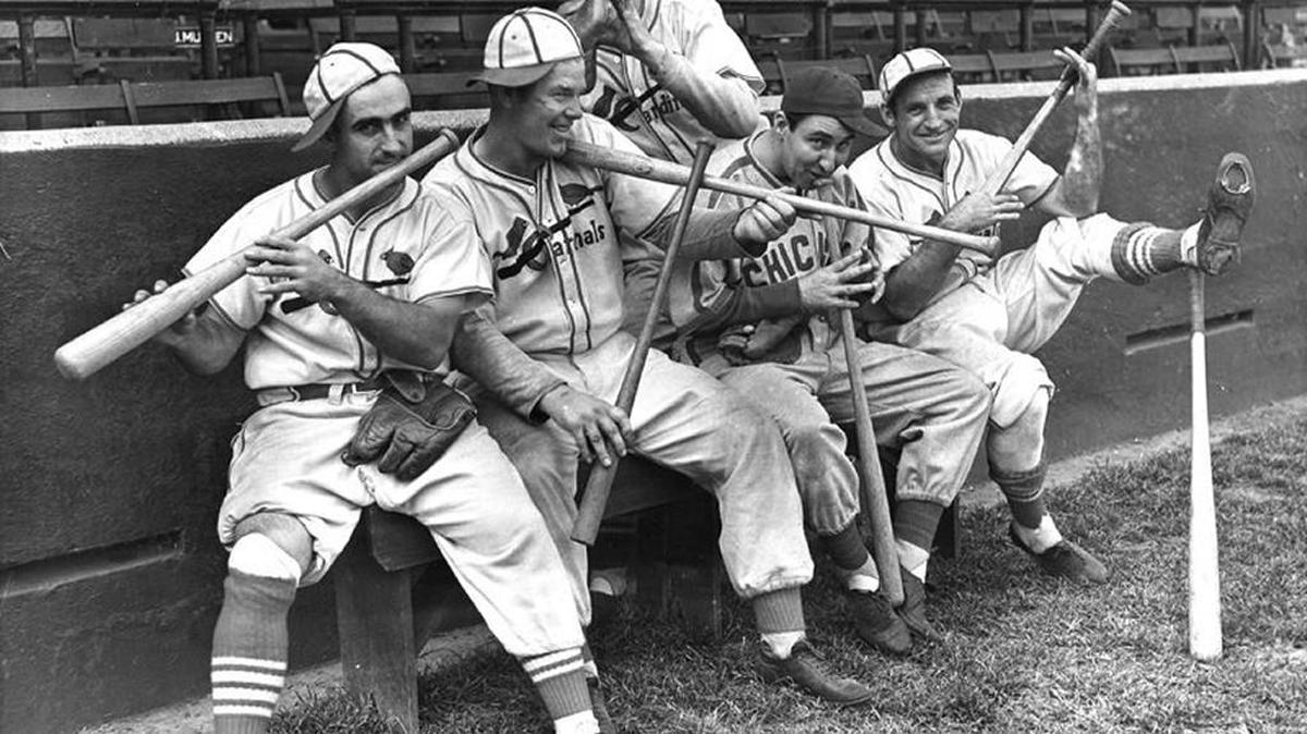 Rip Collins, Chicago first baseman and former Cardinal, joined his old teammates in a burlesque of John Pepper Martin’s mudcat band in St. Louis, Sept. 30, 1938. Left to right: Stan Bordagaray, Bill McGee, Collins, and Pepper himself are dancing out a "tune" on their bats, while Bob Weiland (standing, rear) finds his glove sufficient.