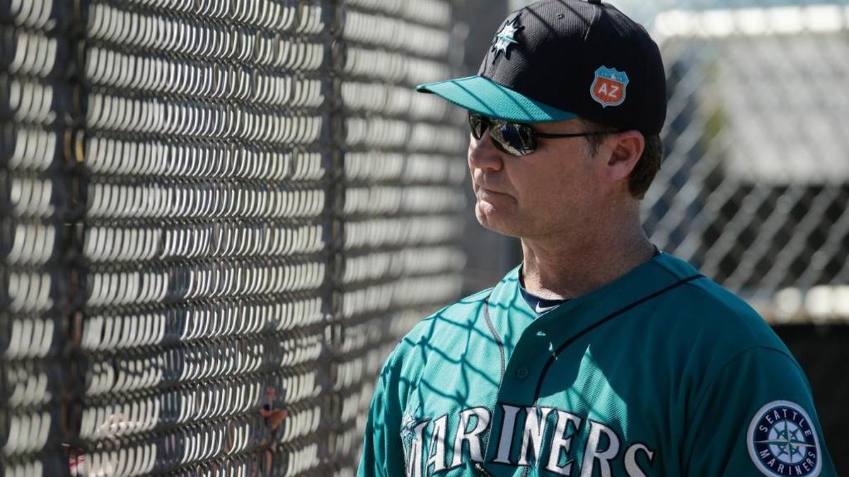 Seattle Mariners manager Scott Servais talks to a fan through a fence during spring training baseball practice Feb. 22, 2016, in Peoria, Ariz.