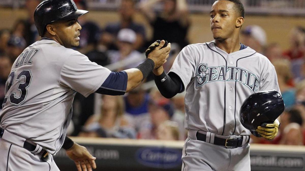 
Rookie Ketel Marte, right, congratulates Nelson Cruz after they scored on Cruz’s two-run home run Friday. Marte walked in five plate appearances in his major league debut. 
