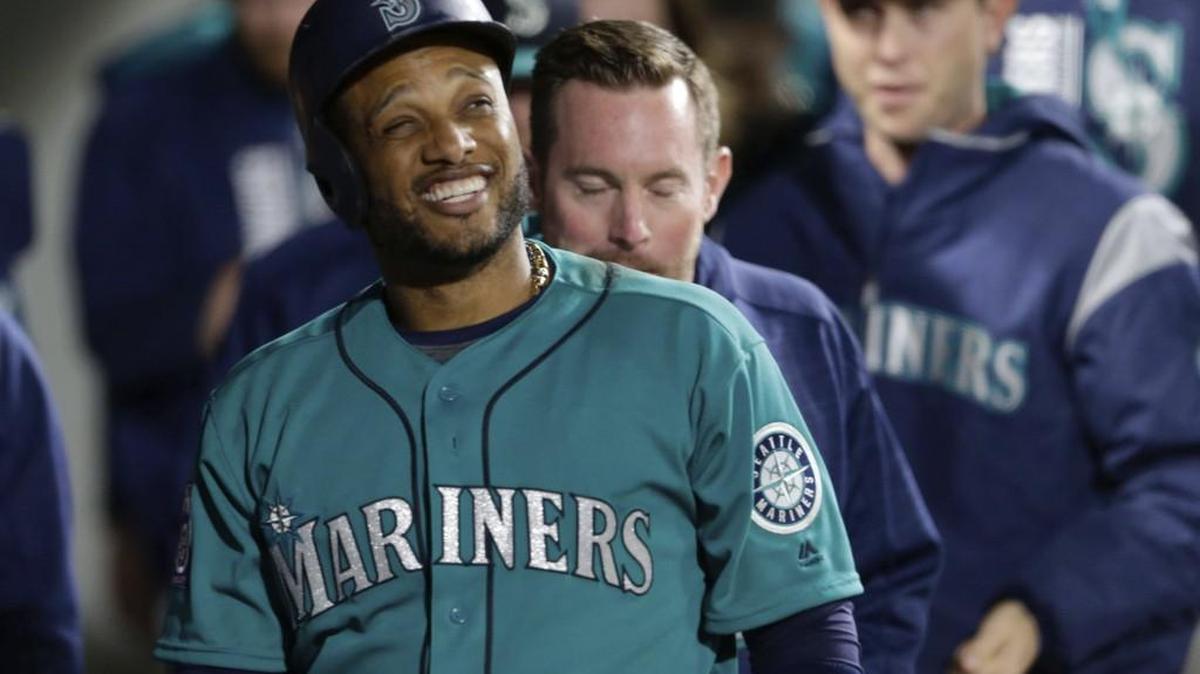 Seattle Mariners' Robinson Cano smiles in the dugout after scoring against the Toronto Blue Jays during the seventh inning of a baseball game, Friday, June 9, 2017, in Seattle.