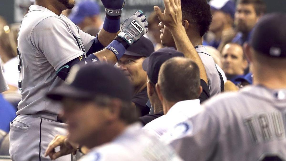 
The Mariners’ Robinson Cano celebrates with teammates after hitting a solo home run during the first inning in an 11-2 victory over the Kansas City Royals on Tuesday in Kansas City, Mo. Cano added a three-run homer in the fourth.
